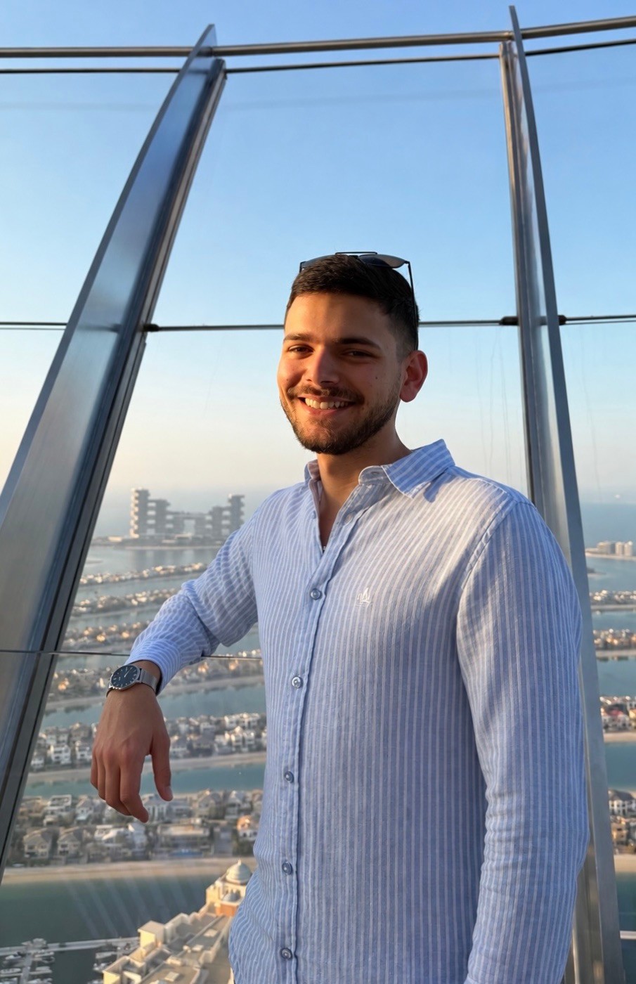 Alex Agius at a glass observation deck high above a coastline